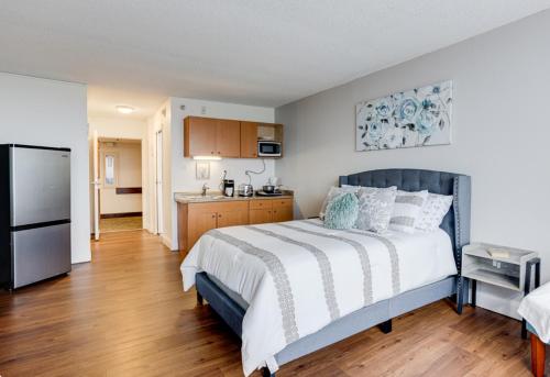 een slaapkamer met een groot bed en een keuken bij The View Studio, Suites and Event Venue in Orlando