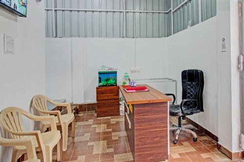 Habitación con escritorio, TV y sillas. en SPOT ON Hotel Tulsi Stay Inn, en Nagpur