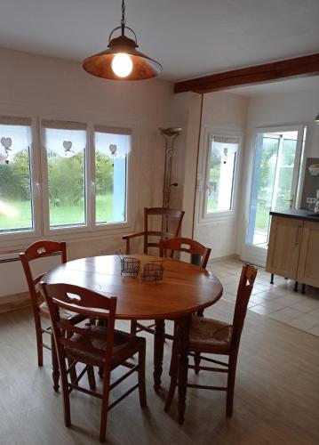 une salle à manger avec une table et des chaises en bois dans l'établissement Le Clos des Anes Maison de campagne de plain-pied, à Sainte-Marguerite-sur-Duclair