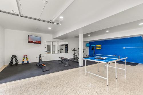 a gym with a ping pong table and exercise bikes at Large Spanish Villa -Hot tub- Pool -Gym- Game Room in Sedona