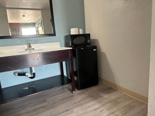 a bathroom with a sink and a small television at Siesta Inn in Fresno