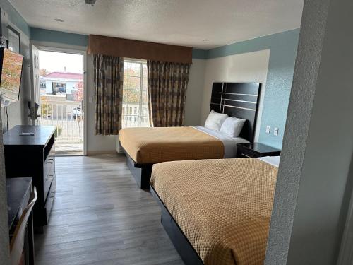 弗雷斯諾的住宿－Siesta Inn，酒店客房设有两张床和窗户。
