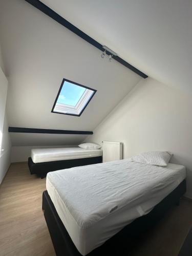 a attic bedroom with a bed and a window at The 40 work or holiday new Appt in Comines