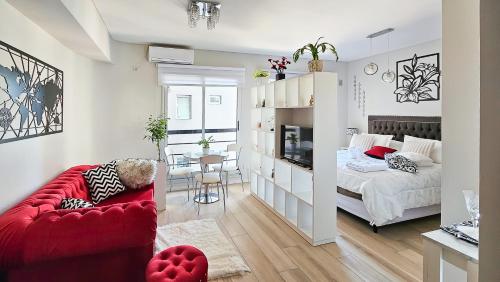 a living room with a red couch and a bedroom at Movistar Arena "Rincón de ensueño" Palermo in Buenos Aires