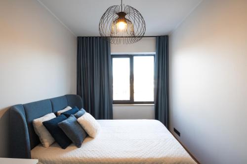 a bedroom with a bed with a blue couch and a window at R64 Premium Apartments in Tartu