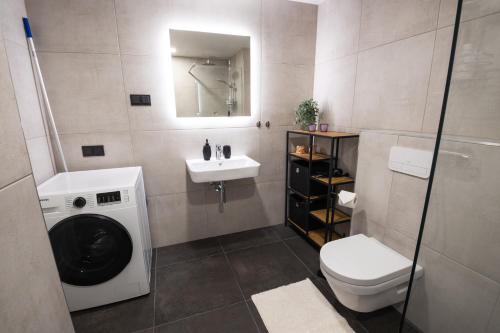 een badkamer met een wasmachine en een wastafel bij R64 Premium Apartments in Tartu