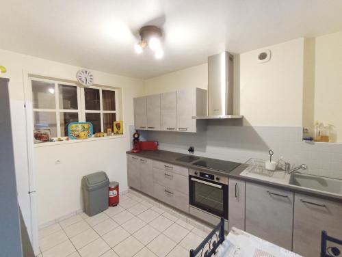 une cuisine avec un évier et une cuisinière four supérieur dans l'établissement Maison de ville de 95M2, à Montmorillon