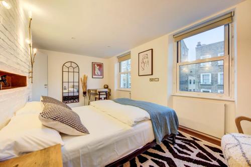 a bedroom with two beds and a window at Prime Location Marylebone 4 Bed Designer Flat in London