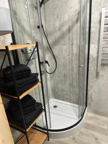 a shower with a rack of towels in a bathroom at Osada Wichrowe Wzgórze in Rajcza