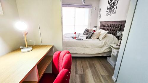 a bedroom with a bed and a desk with a red chair at Movistar Arena "Rincón de ensueño" Palermo in Buenos Aires