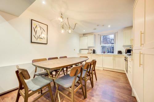 a kitchen and dining room with a table and chairs at Prime Location Marylebone 4 Bed Designer Flat in London