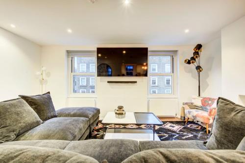 a living room with a couch and a table at Prime Location Marylebone 4 Bed Designer Flat in London