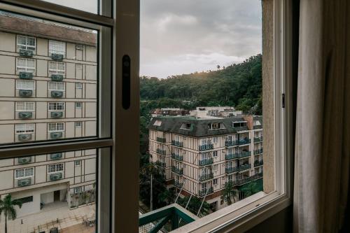 a window with a view of a building at Studios Exclusivos Xavishome Granja Brasil Itaipava in Itaipava