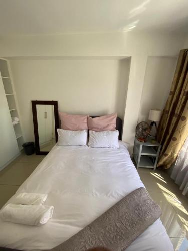 a large white bed in a room with a mirror at Ceres no. 10 in Durban