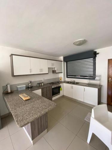 a kitchen with white cabinets and a counter top at Ceres no. 10 in Durban