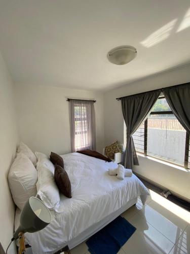 a bedroom with a white bed with pillows and a window at Ceres no. 10 in Durban