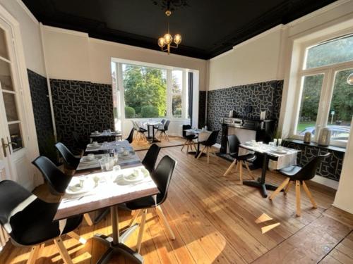 uma sala de jantar com mesas e cadeiras num restaurante em La Villa Blanche Spa em Spa