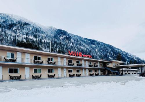a large building with a snow covered mountain at Villa Motel in Nelson