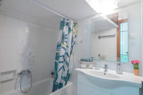 a white bathroom with a sink and a mirror at Kassi Hanni Guesthouse in Thessaloniki