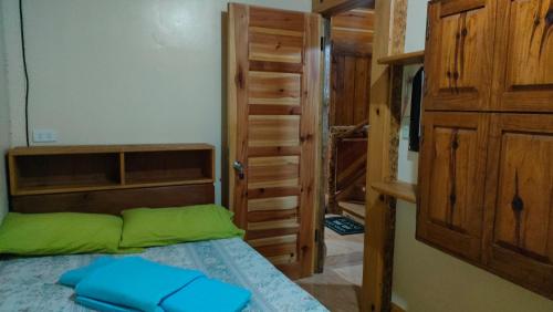 a bedroom with a bed and a wooden closet at Acai's Transient House in Sagada