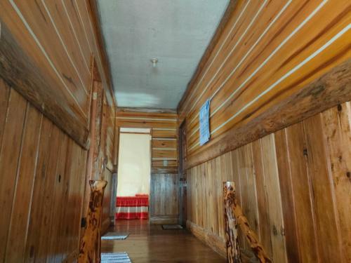 Habitación con paredes revestidas de madera y techo. en Acai's Transient House, en Sagada