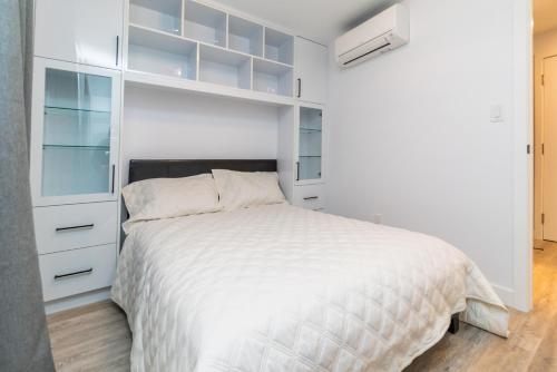 a white bedroom with a white bed and a closet at My cozy home in Toronto in Toronto