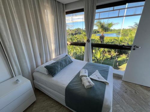 sypialnia z łóżkiem i dużym oknem w obiekcie Villaggio Orizzonte w mieście Salvador