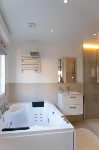 a large white bath tub in a bathroom at Zen et Romantique Room - Harmonie in Moulins