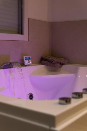 a bathroom with a sink with purple lighting at Zen et Romantique Room - Harmonie in Moulins