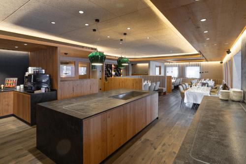 a restaurant with a kitchen and a dining room at Hotel Krondlhof in Brunico