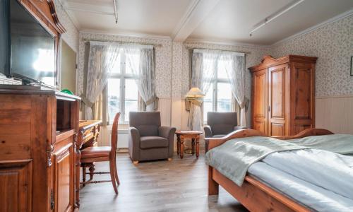 Schlafzimmer mit einem Bett, einem Schreibtisch und Stühlen in der Unterkunft Thon Partner Hotel Selbusjøen in Selbu