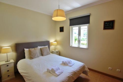 a bedroom with a bed with two towels on it at Da Praia Apartment - Pool & Tenis in Vilamoura