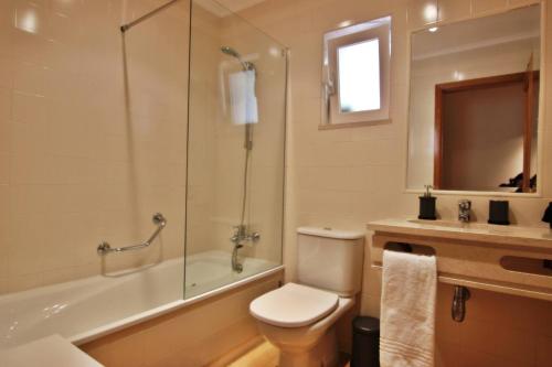 a bathroom with a toilet and a shower and a sink at Da Praia Apartment - Pool & Tenis in Vilamoura