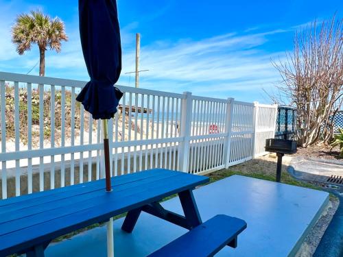 a blue picnic table with an umbrella on it at Sugar Sands - Ocean front at Symphony Beach Club ! in Ormond Beach