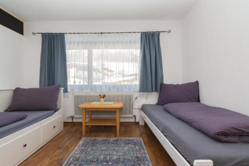 a room with two beds and a table at Haus Maria in Ellmau