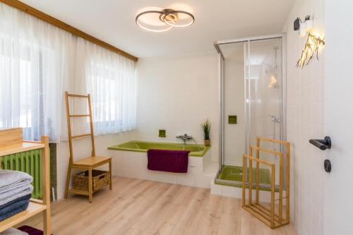 a bathroom with a green tub and a shower at Haus Maria in Ellmau