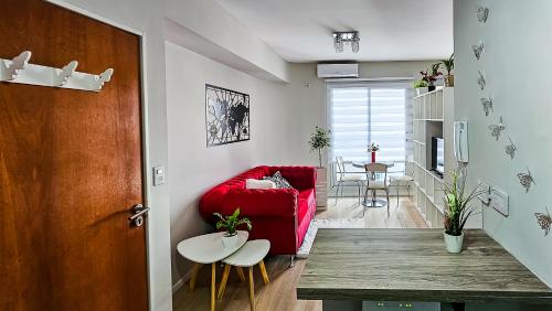 a living room with a red couch and a table at Movistar Arena "Rincón de ensueño" Palermo in Buenos Aires