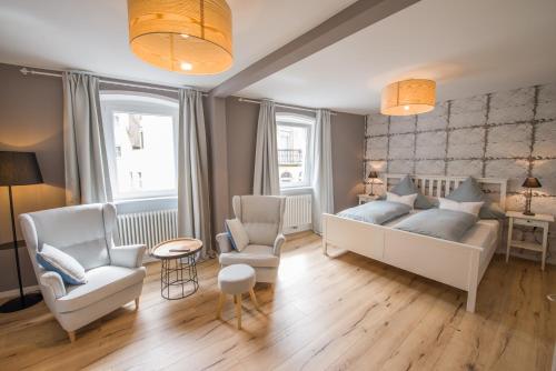 1 dormitorio con 1 cama blanca y 2 sillas en Brombeerhaisel, en Sankt Martin