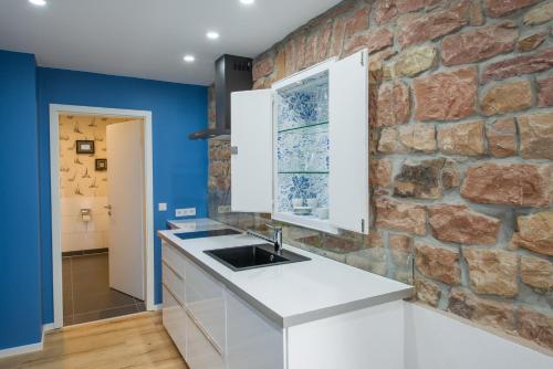 eine Küche mit blauen Wänden und einer Steinmauer in der Unterkunft Brombeerhaisel in Sankt Martin