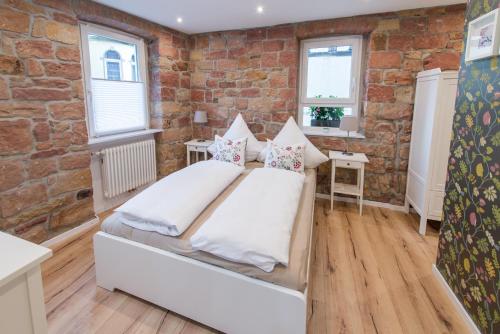 ein Schlafzimmer mit einem Bett und einer Ziegelwand in der Unterkunft Brombeerhaisel in Sankt Martin