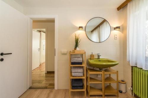 a bathroom with a green sink and a mirror at Haus Maria in Ellmau