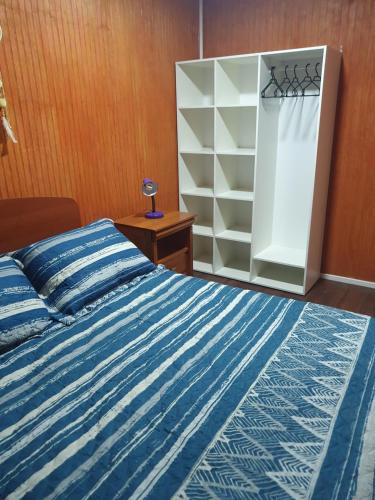 ein Schlafzimmer mit einem Bett und einem Bücherregal in der Unterkunft Casa en Peñuelas in Coquimbo