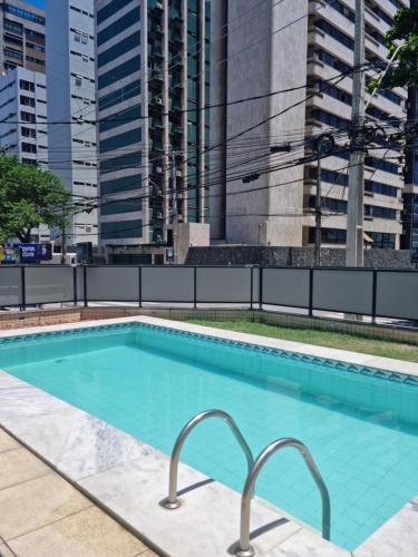 a swimming pool in a city with tall buildings at BOA VIAGEM FLAT 106 in Recife