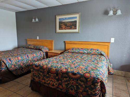 a hotel room with two beds and a picture on the wall at Austin Motor Inn in Austin