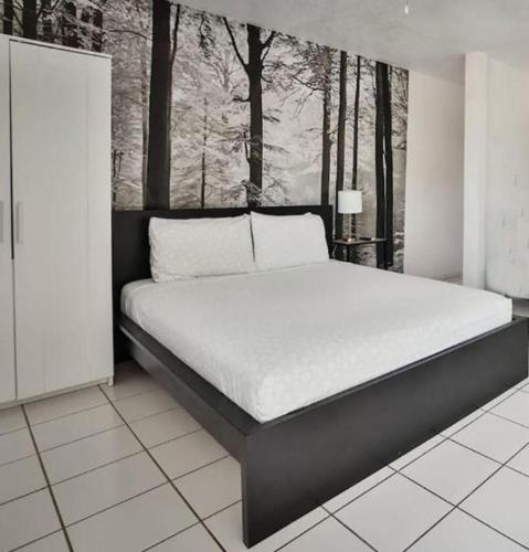 a bedroom with a large bed in a room with trees at Krymwood Flats Wynwood in Miami