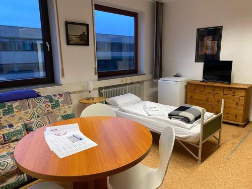 a room with a table and a bed and a couch at Hotel Ditzingen in Ditzingen