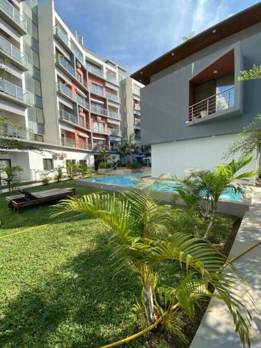 a courtyard of a building with a pool and palm trees at Apartment D Aqua view, Bijilo in Bijilo