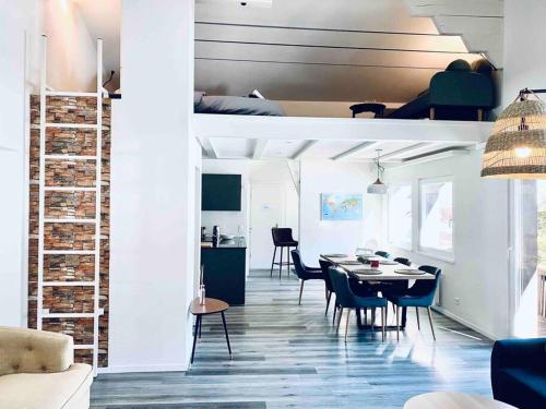 a dining room and living room with a table and chairs at Unique Penthouse with Gallery and Mountain View in Kandersteg