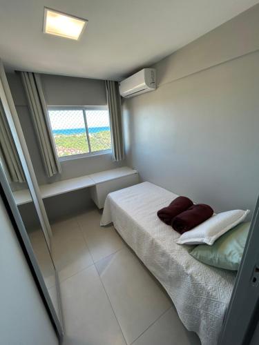 ein kleines Schlafzimmer mit einem Bett und einem Fenster in der Unterkunft Meu aconchego em Maceió - 2qts com ar e 1 vaga de garagem in Maceió