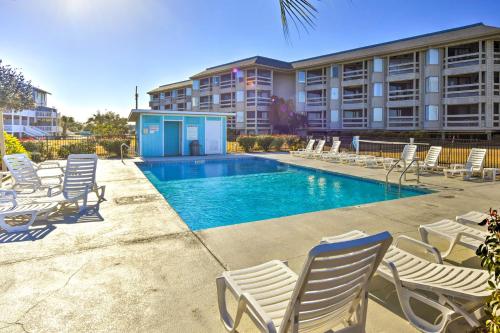a swimming pool with lounge chairs and a building at St Helena Island Vacation Rental Walk to Beach! in Oceanmarsh Subdivision